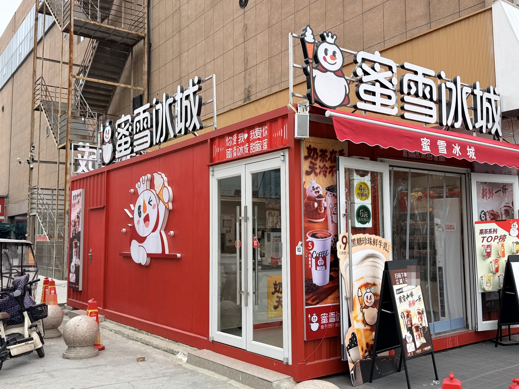 河南开封兰考兰美广场蜜雪冰城加盟店开业后的门头、玻璃门与遮阳篷。