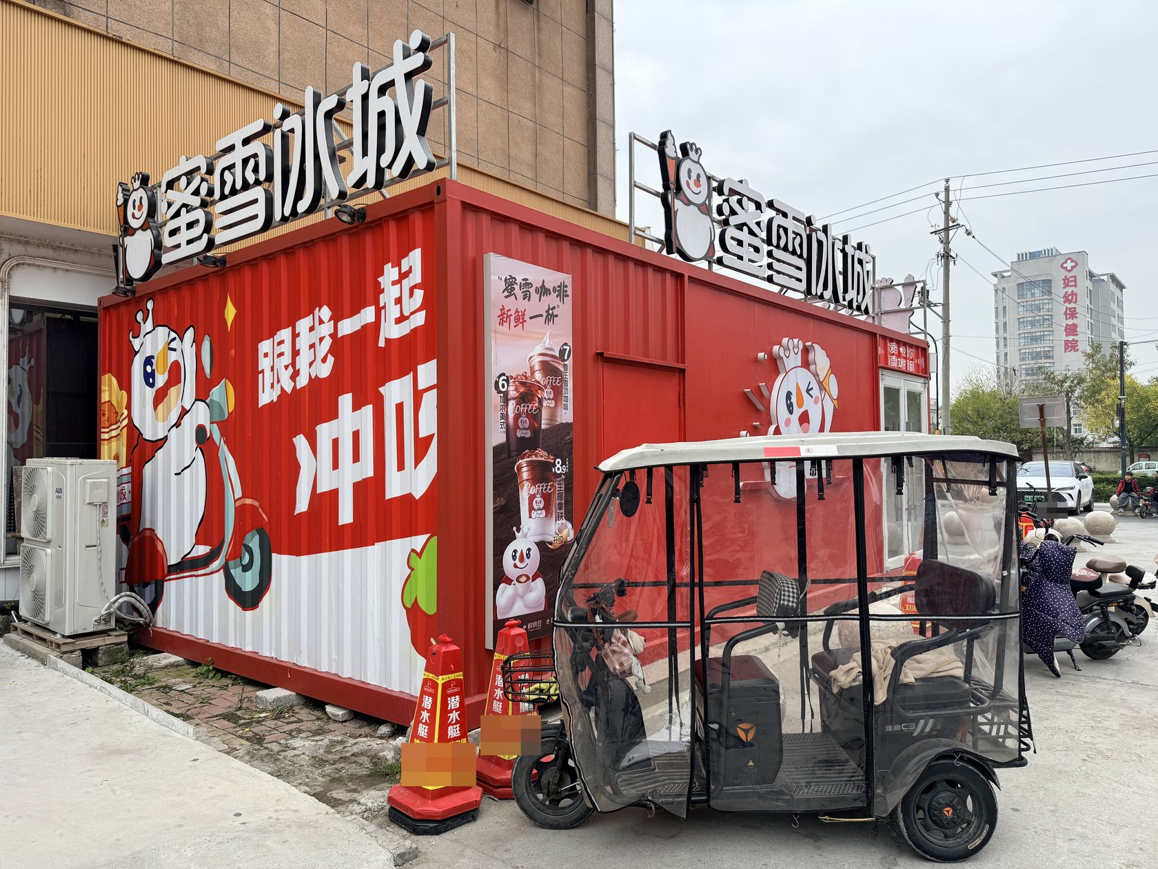 兰美广场蜜雪冰城加盟店侧面,可见红色波纹箱体、品牌画面和屋顶店招。
