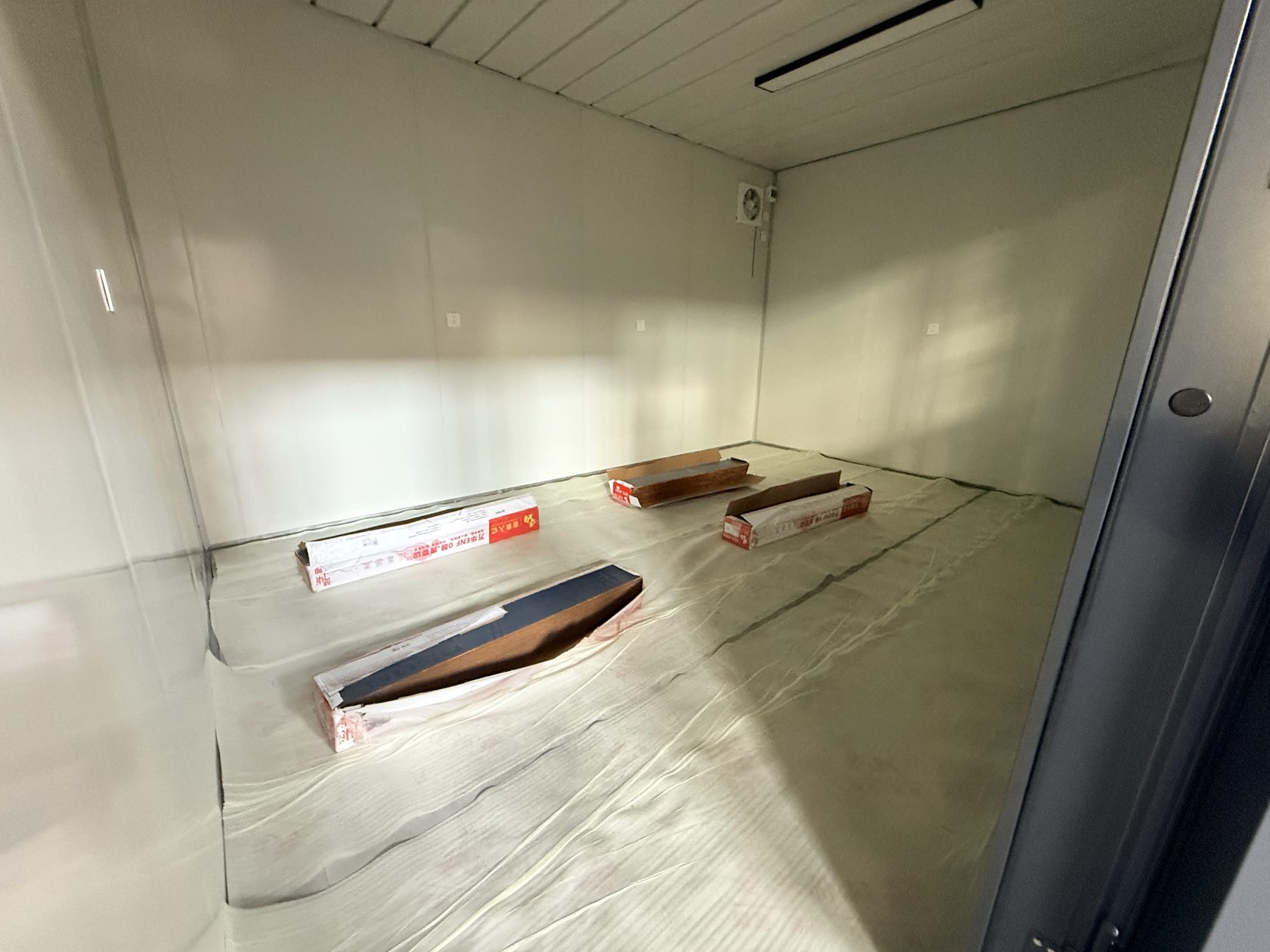 洛阳壁球馆集装箱配套浅色室内饰面,厂内内装后期:浅色墙面、地板及顶部设备,地面仍留有收尾材料。