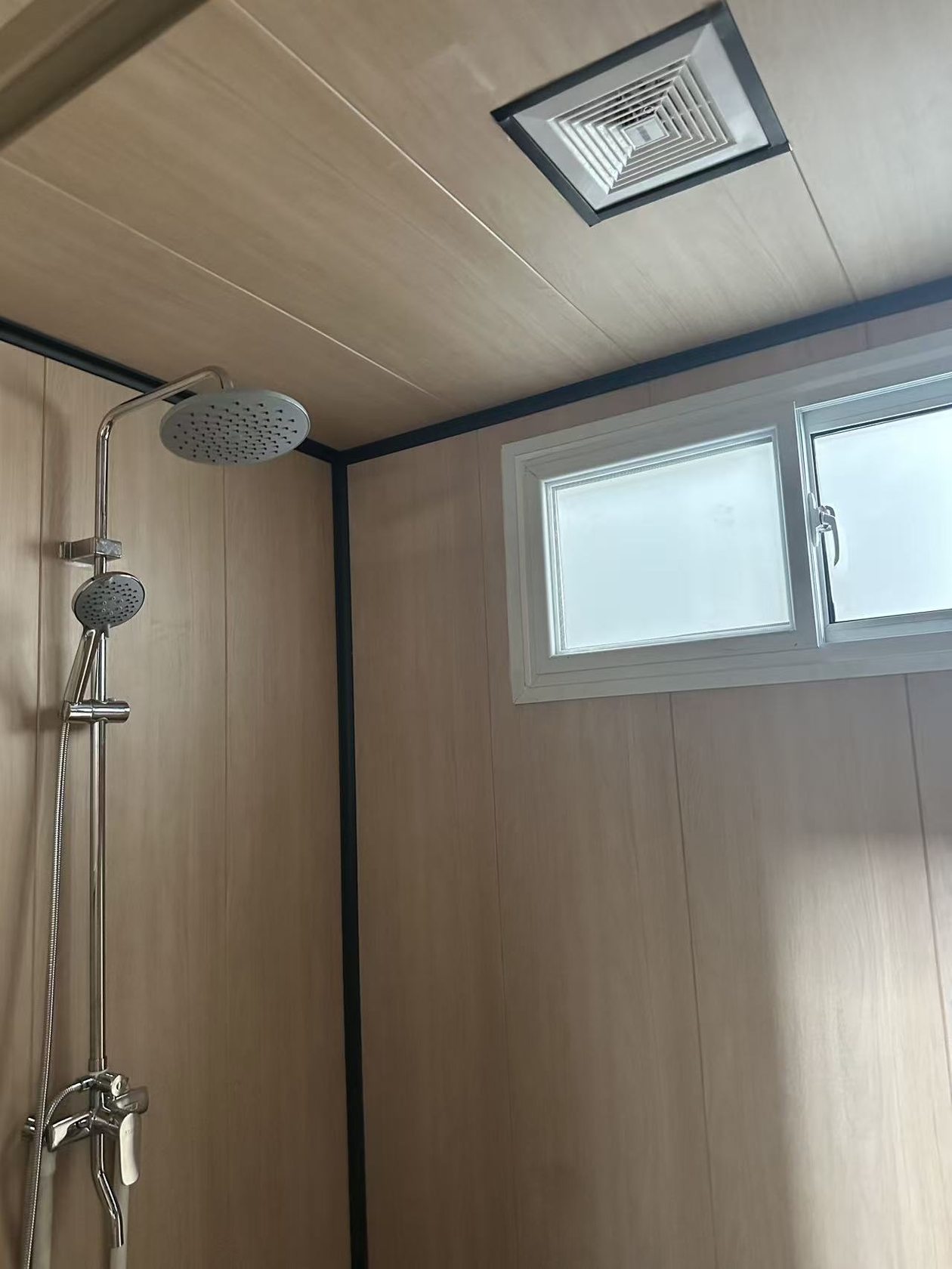 洛阳壁球馆集装箱淋浴间内部,首批淋浴间内部:画面可见顶喷及手持花洒、磨砂玻璃窗和顶置排风。