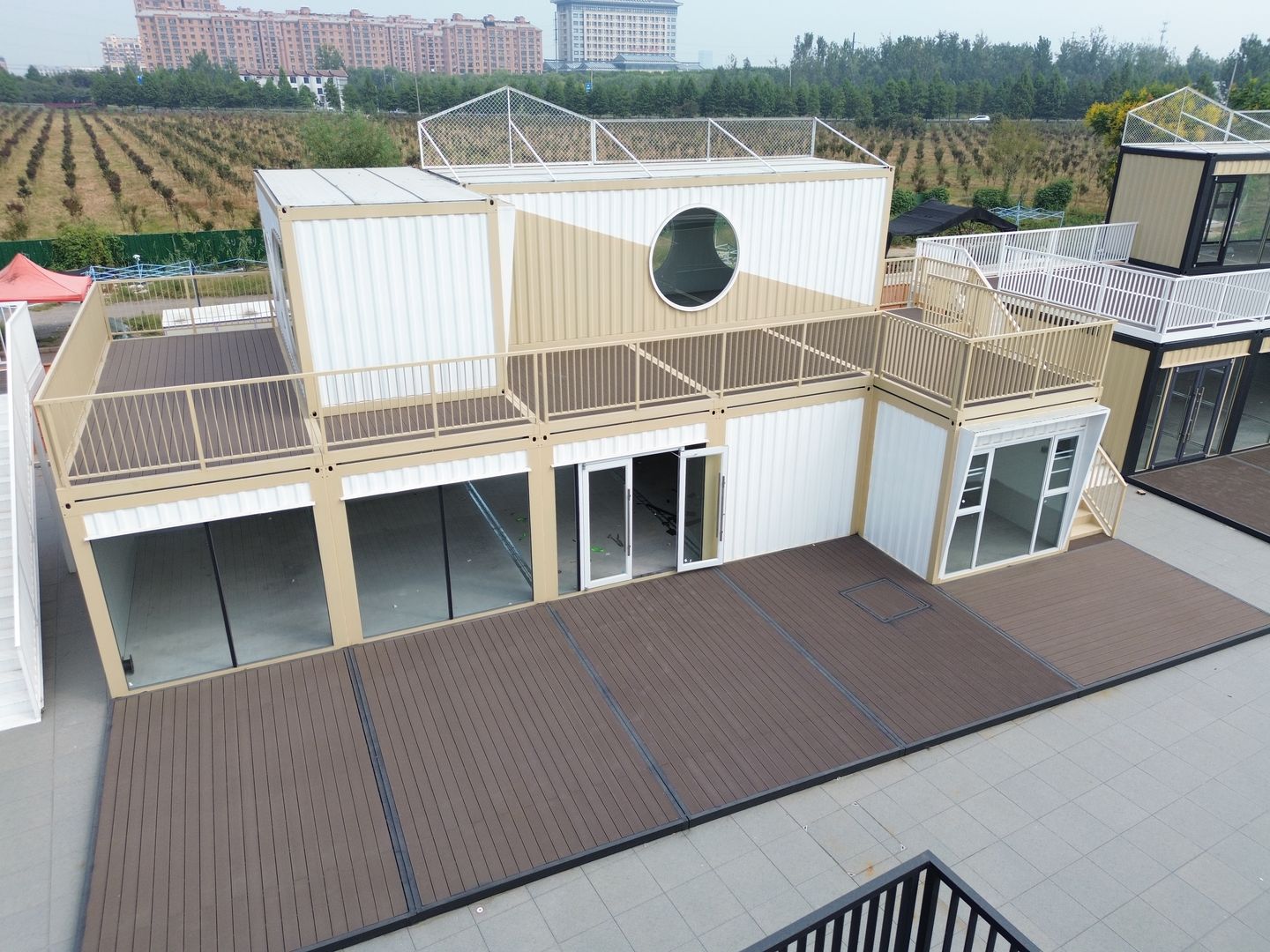 江苏徐州丰县大汉丰景圆窗双层集装箱商铺,完工实拍:圆窗与米白色墙面构成另一组店铺立面。