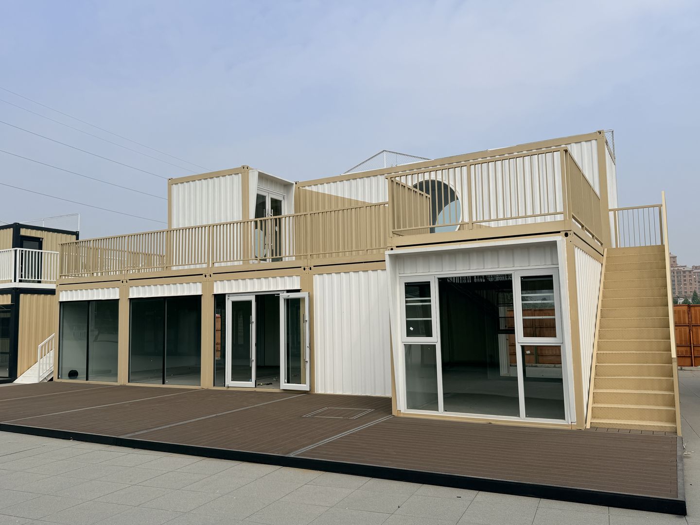 江苏徐州丰县大汉丰景圆窗组合商铺完工实景,米白双色墙面、圆窗、二层栏杆与室外楼梯。