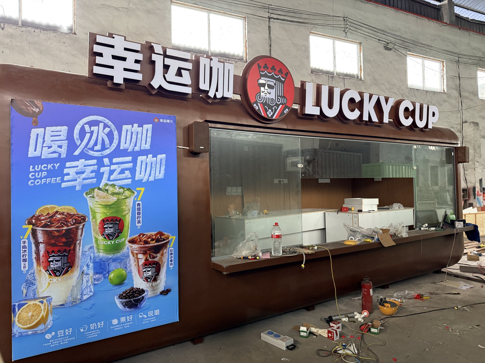 厂内门店正面实拍，可见幸运咖品牌标识、玻璃售卖窗口和柜体。