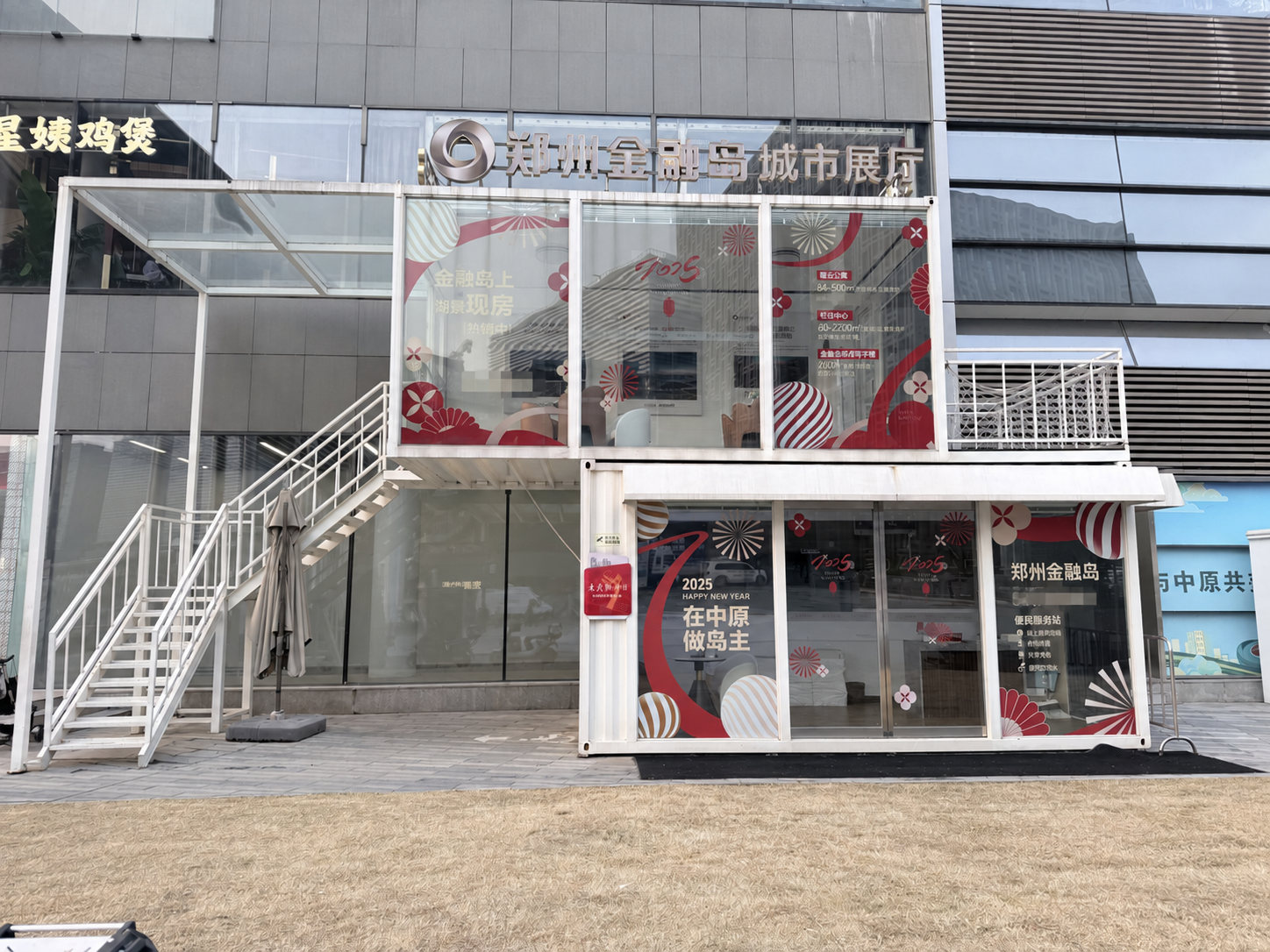 郑州金融岛集装箱售楼处正立面完工实景,展示品牌标识、玻璃围护和错位箱体