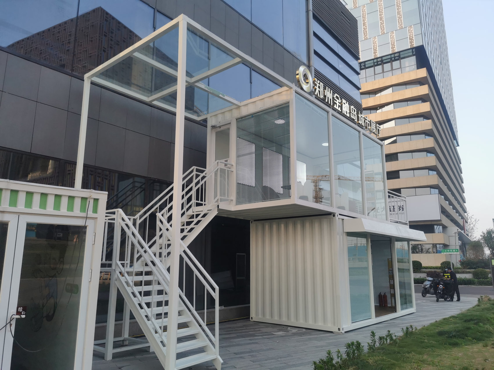 郑州金融岛集装箱售楼处成品侧前方实景,展示两层错位组合与楼梯