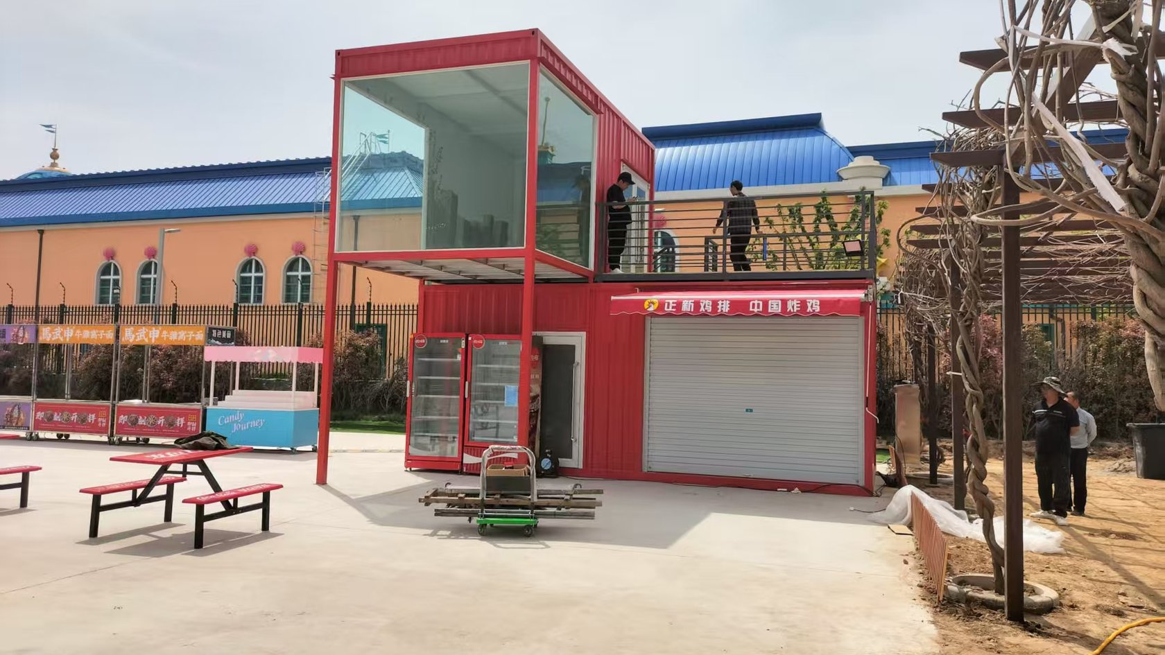 郑州市中牟县海昌海洋公园正新鸡排二层集装箱商铺现场外观,红色箱体、二层玻璃休息区与露台已经形成。