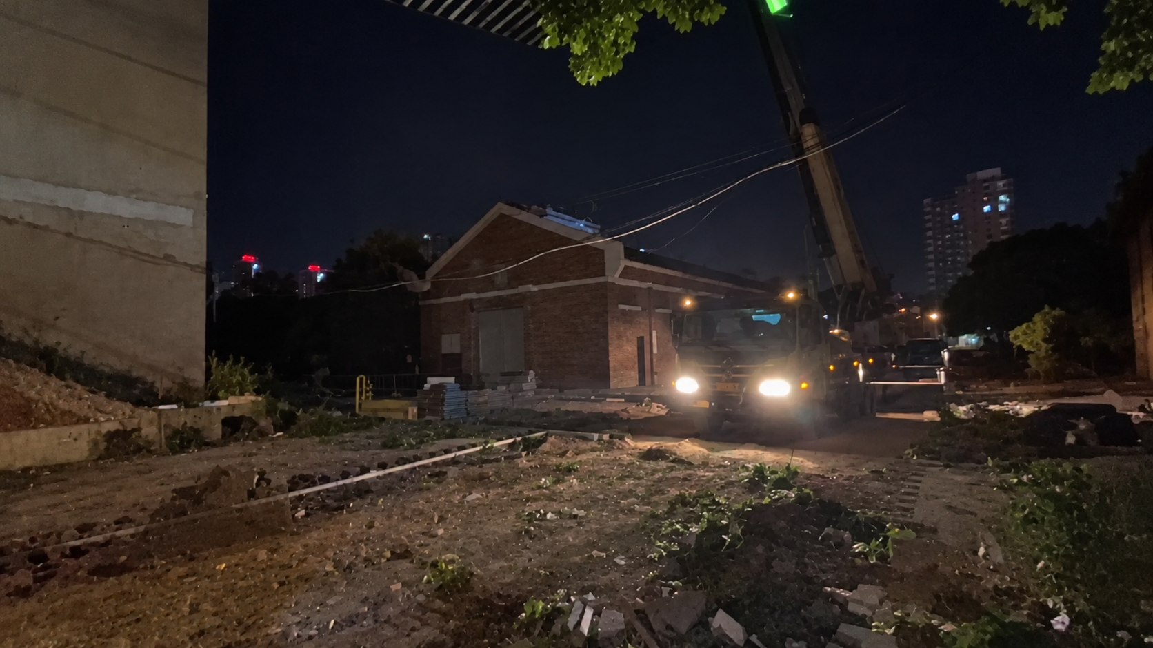 郑州紫荆创意园集装箱办公室夜间现场视频截图,可见吊车、吊臂、照明与现场环境,画面为AI提亮降噪优化版。